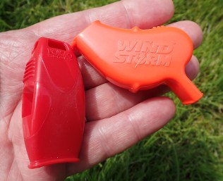 The relative sizes of the Fox 40 Sharx and Wind Storm compared side by side in the hand