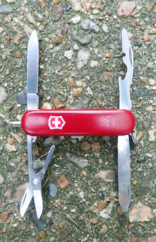 The small Midnight Manager multi-tool from Victorinox contains one of the most useful set of tools, including a pen and small LED light. This is the earlier version that has a red light, operated by pressing the shield on the scale