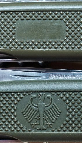 The German Army Knife carries the German Eagle on one scale. The civilian version had a blank space where a name could be inserted