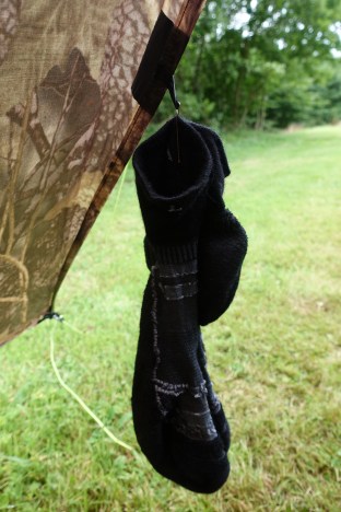 Bobby pin being used to hand a washed Darn Tuff sock at tent door to allow it to dry