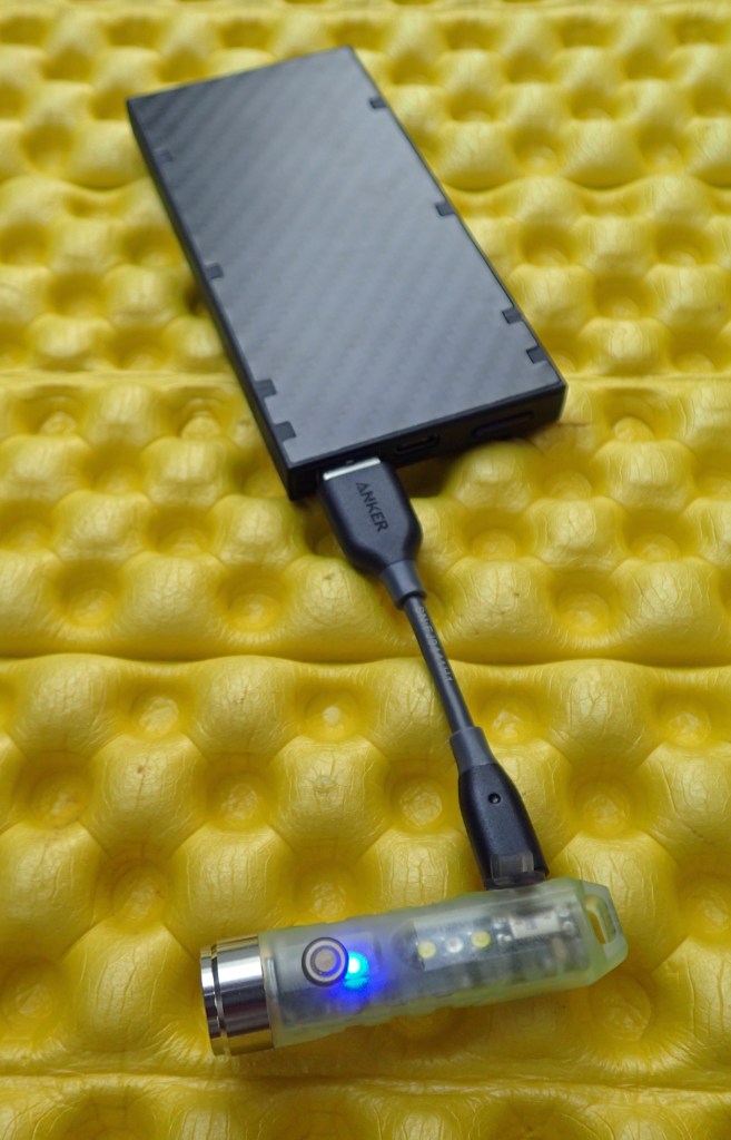 Aurora A5x on charge, a 'heartbeat' blue charge light turns solid when fully charged. Shown with shortie Anker lead and Nitecore NB10000