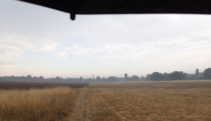 Crossing arable with a simple treeking umbrella to keet the majority of  light rain off me