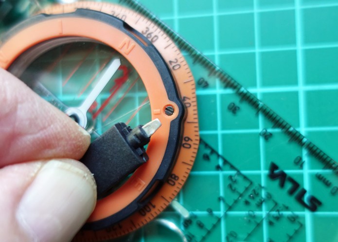 Snap connector, when unsnapped, reveals small screwdriver for adjusting declination on the compass bezel