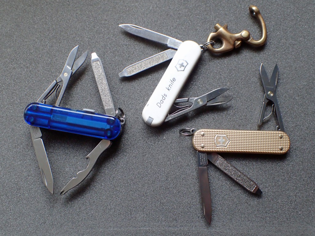 Three of the Victorinox 58mm frame knives EDC's by Three Points of the Compass- top: Classic SD, right: Classic SD Alox, and left: the Midnite Manager, that adds a little more utility to the Classic