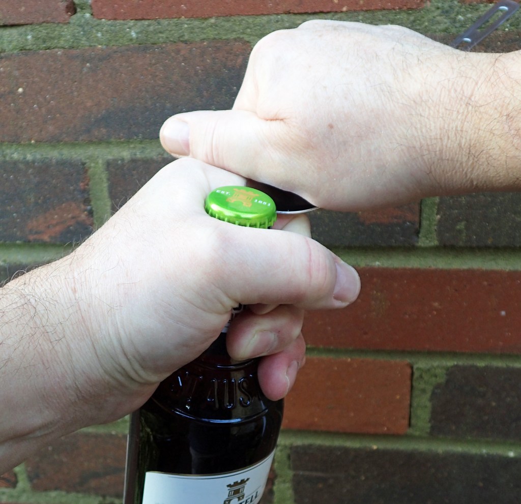 Levering a beer bottle cap off with the bowl of a spoon. This a titanium long handled spoon but a short one works just as well