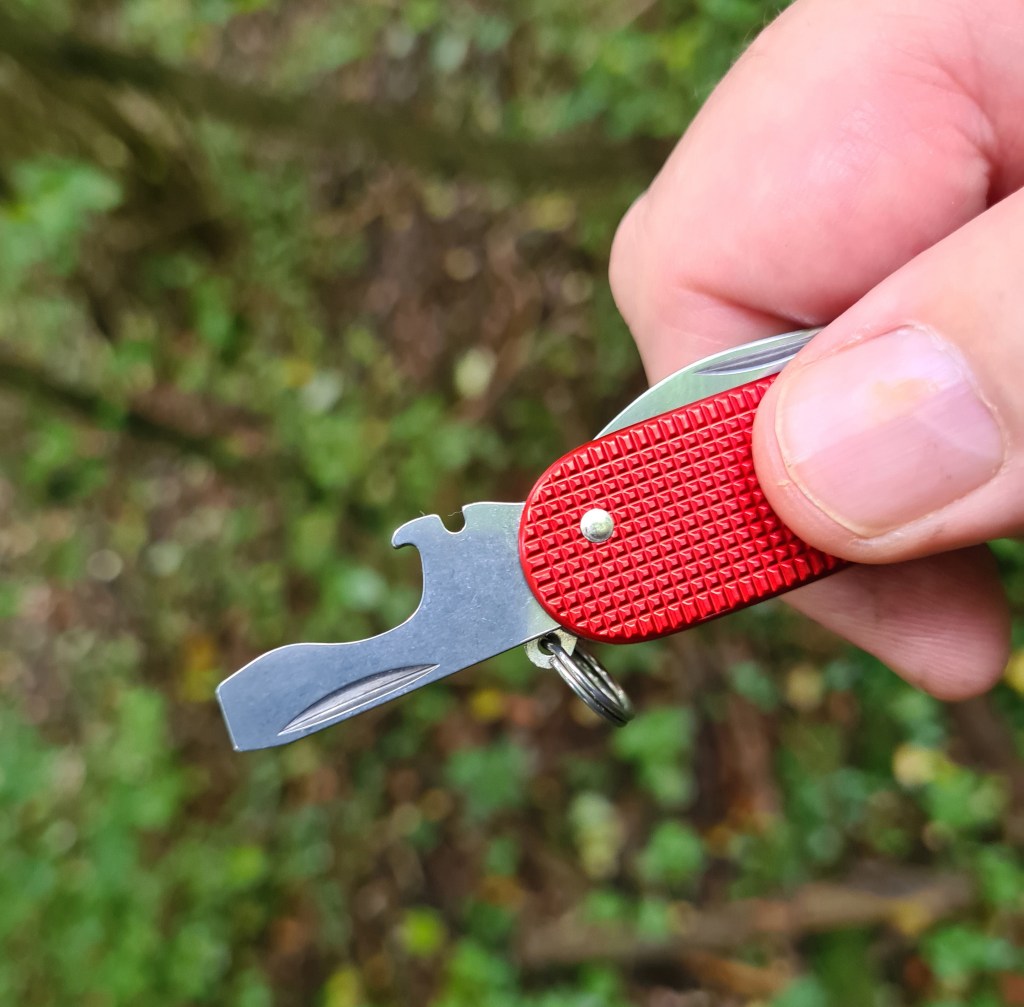 Bottle/cap lifter with wire bender/stripper and wide flat screwdriver tip