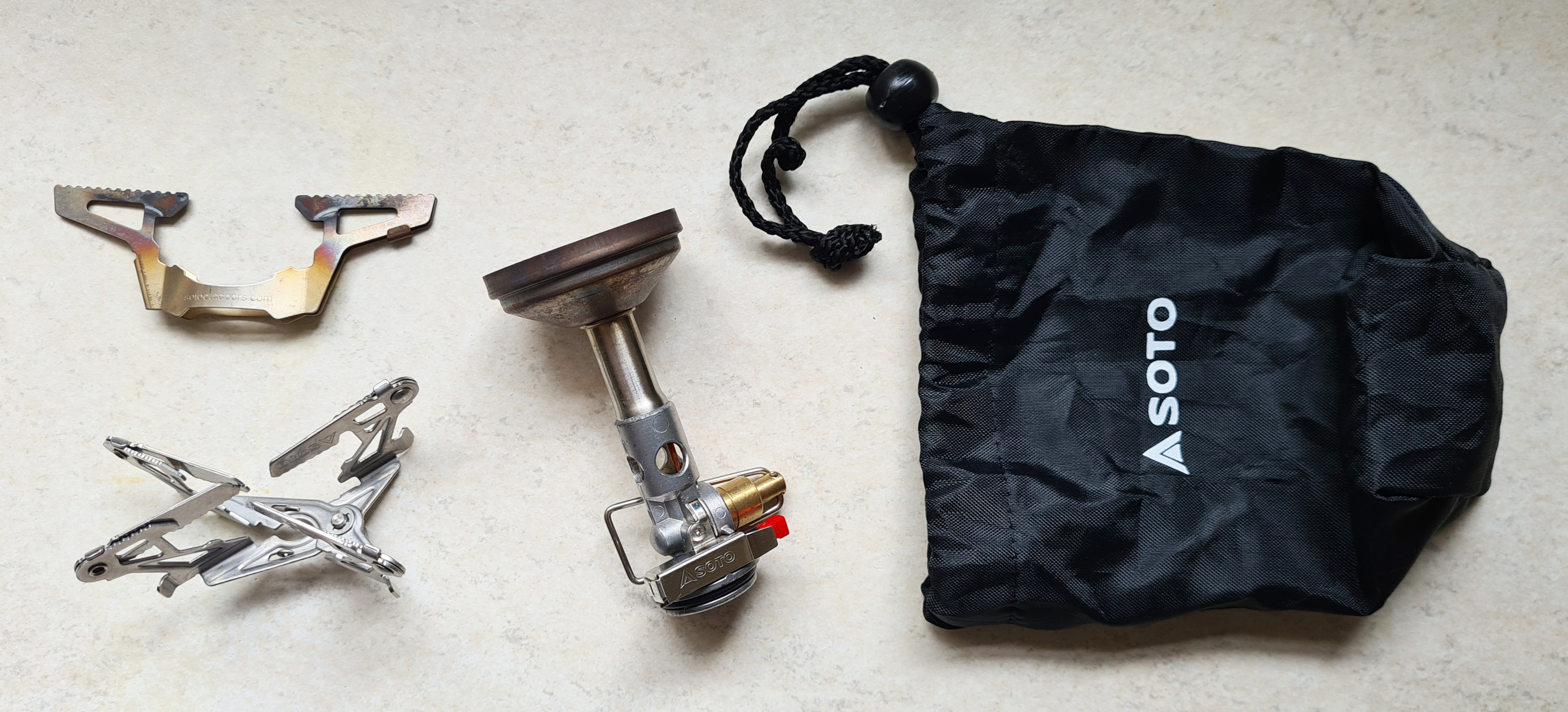 When purchased, the Soto Windmaster comes with a small and tough drawcord baggie and the 4Flex pot support. The TriFlex three-arm support (top left) is an optional extra