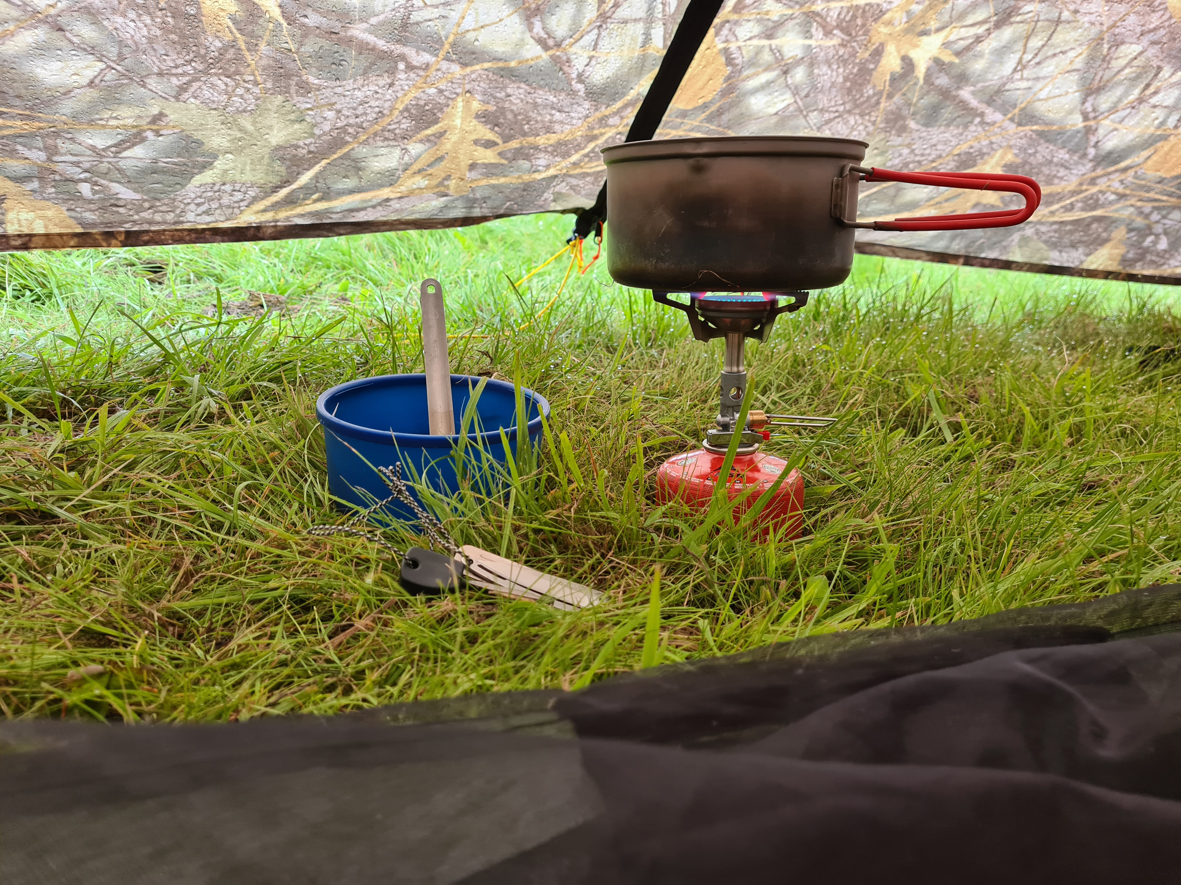 Boiling water inside the vestibule of MLD Duomid. TriFlex three-priong pot support can easily handle the wide bottom Evernew 900ml pan. Wolds Way