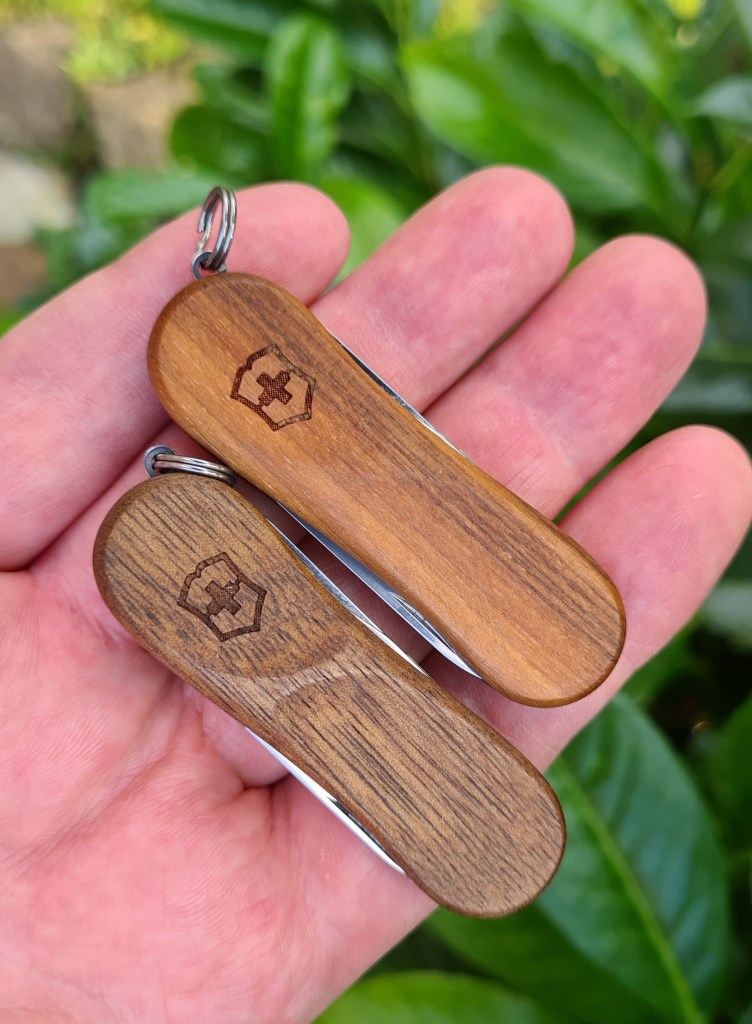 Two Evowood 81 knives demonstrate the variance that can be found in their wooden scales