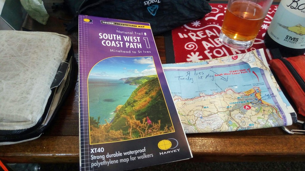 A pub stop on the South West Coast Path in 2018. Time for a pint and check of progress on Harvey map