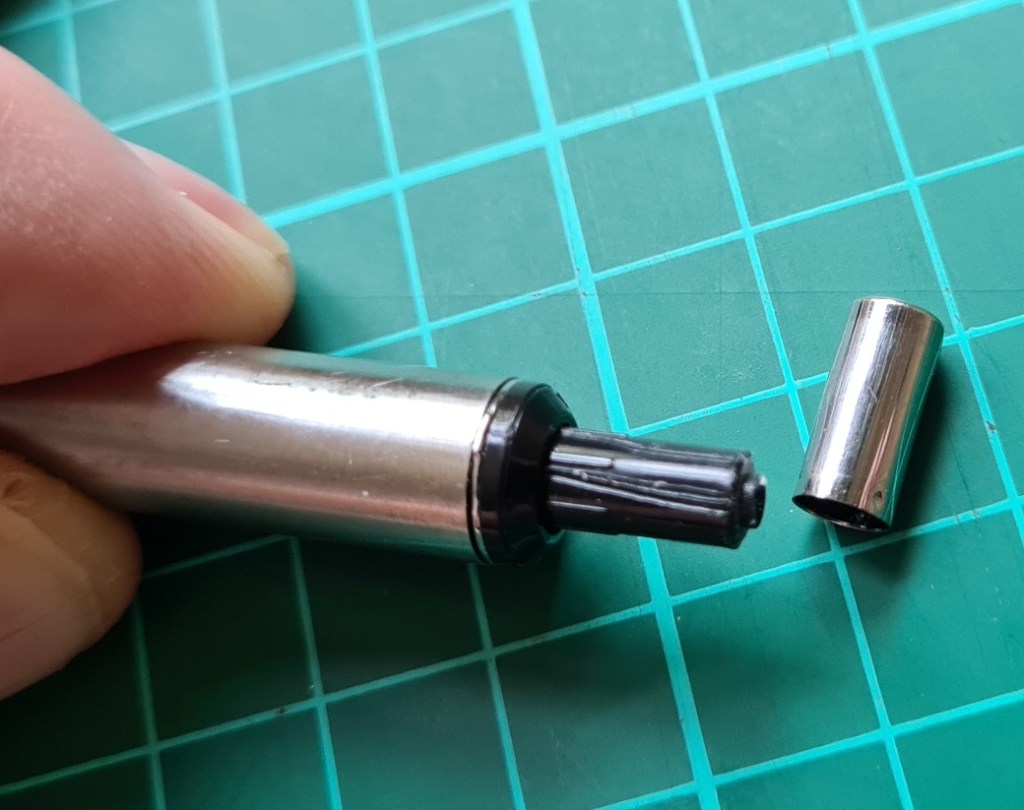 Plastic button on original F-701 has a thin metal cover