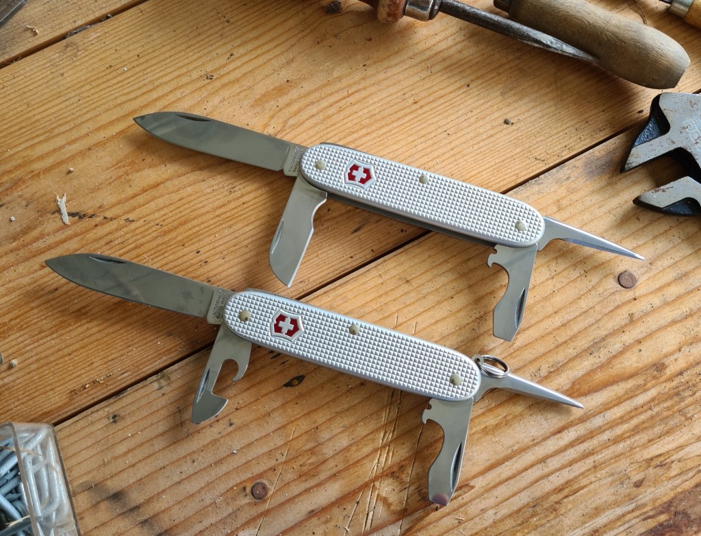 The Victorinox Pioneer varies from the Pioneer Electrician (top) by just one tool