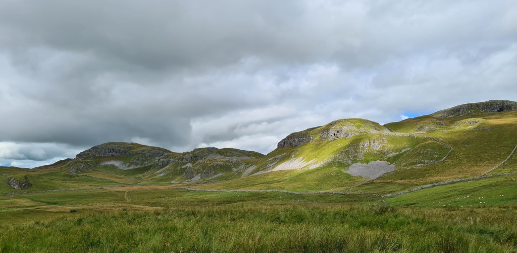 Craggy outcrops overlook the road walk down to Settle