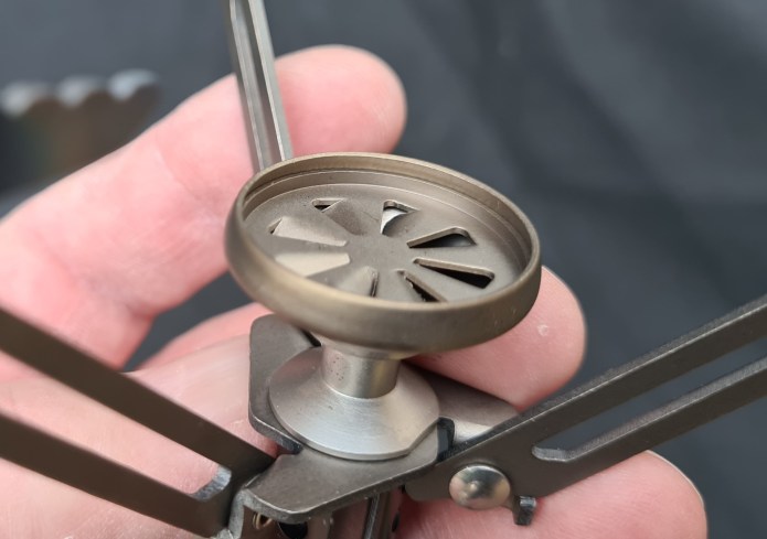 Burner head design creates a circulating vortex flame. Note lip around circumference that offers a little protection from side breezes