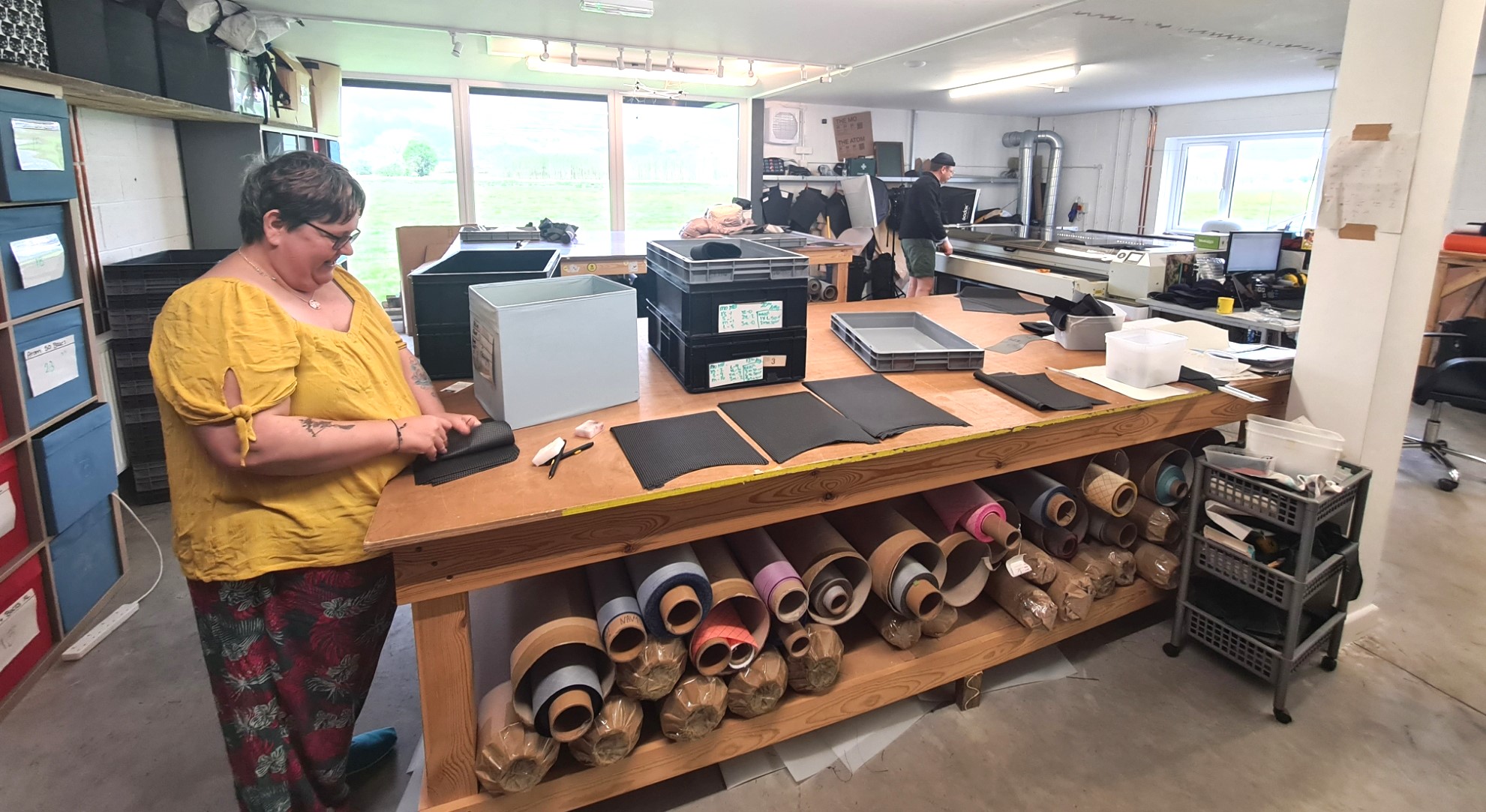 Jo, in the foreground, used to cut packs by hand. As many as thirty in a day. A new and expensive laser cutter increased turn out and accuracy