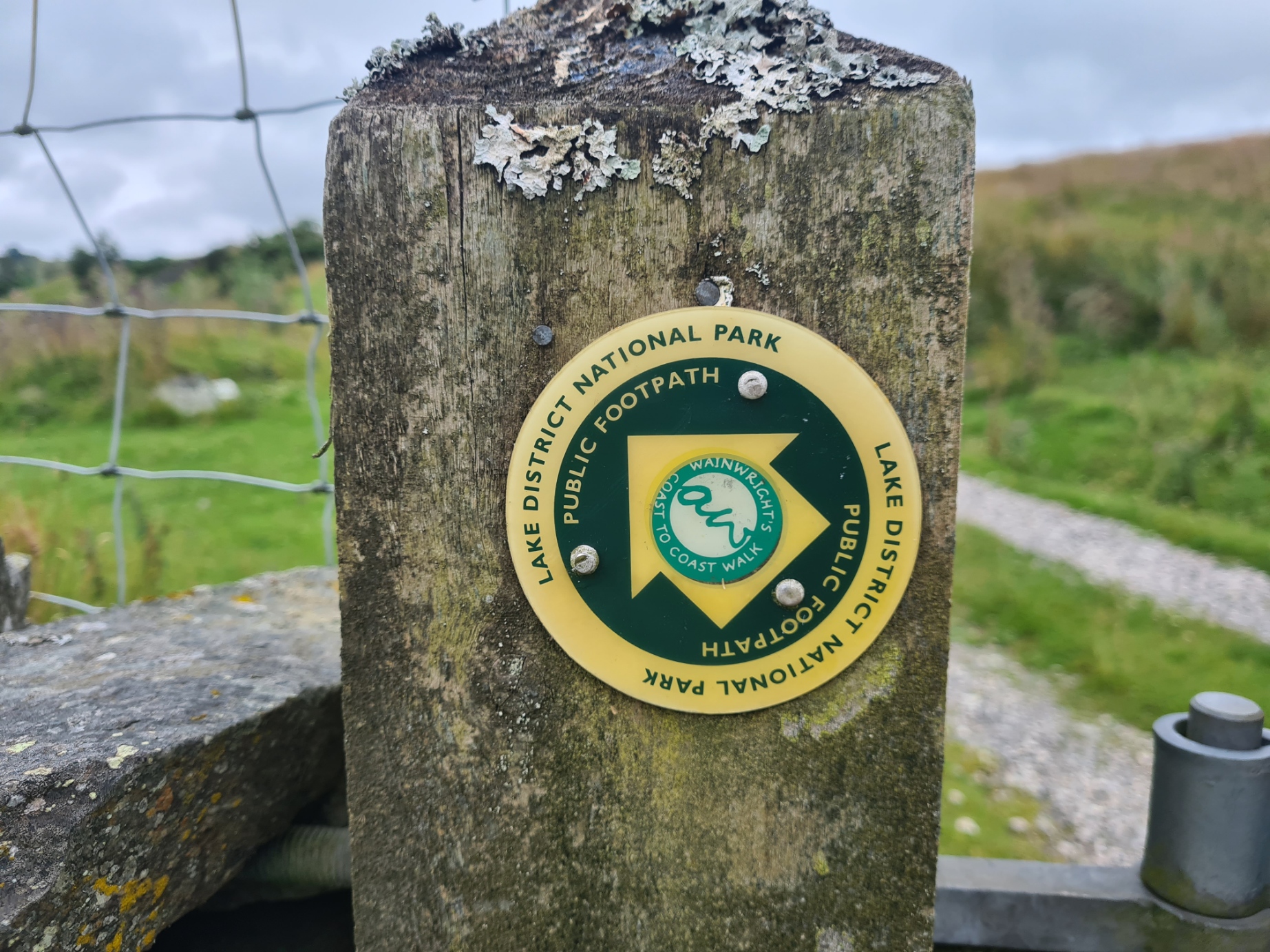 Wainwright's Coast to Coast sticker on footpath marker in the Lake District